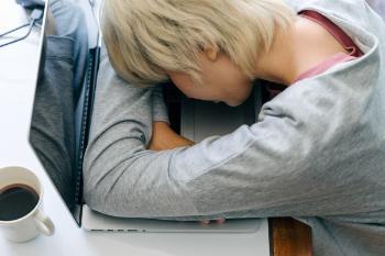 person asleep with arms on table