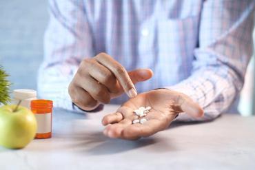 person counting tablets in hand