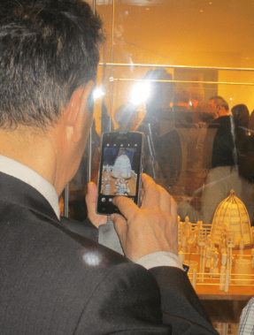 a person taking a picture of a model size building