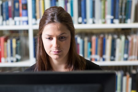 A student in front of a computer in a library