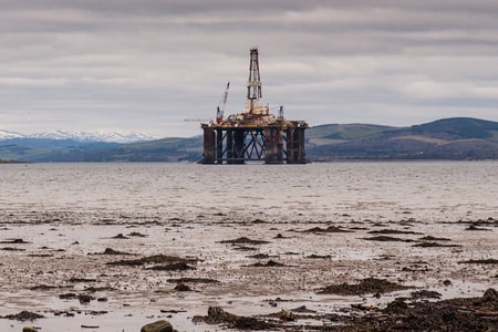 an oil rig near a muddy beach