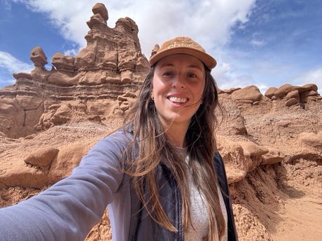 Someone standing in front of a rock formation